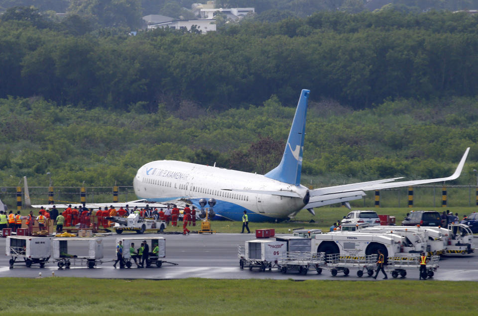 A Boeing passenger plane from China, a Xiamen Air, sits on the grassy portion of the runway of the Ninoy Aquino International Airport after it skidded off the runway while landing Friday, Aug. 17, 2018 in suburban Pasay city southeast of Manila, Philippines. All the passengers and crew of Xiamen Air Flight 8667 were safe and were taken to an airport terminal, where they were given blankets and food before being taken to a hotel. (AP Photo/Bullit Marquez)