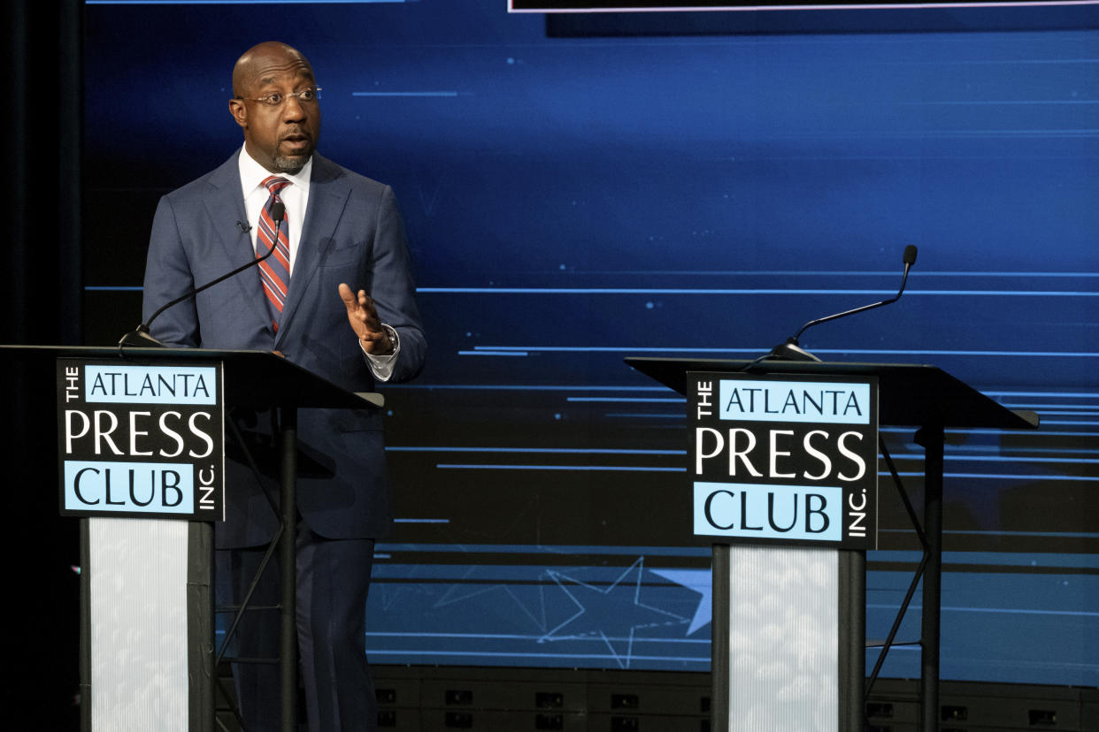 Sen. Raphael Warnock, D-Ga., speaks next to an empty podium set up for Republican challenger Herschel Walker, who was invited but did not attend, during a U.S. Senate debate as part of the Atlanta Press Club Loudermilk-Young Debate Series in Atlanta on Sunday, Oct. 16, 2022. (AP Photo/Ben Gray)