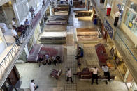 Iranian merchants conduct their business at a carpet market of the old main bazaar in Tehran, Iran, Sunday, June 23, 2019. As the U.S. piles sanction after sanction on Iran, it’s the average person who feels it the most. Depreciation and inflation makes everything more expensive. A simple cell phone is about two months’ salary for the average government worker, while a single iPhone costs 10-months’ salary. (AP Photo/Ebrahim Noroozi)