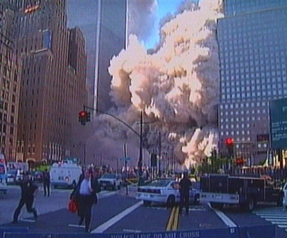 Los peatones y los policías corren mientras que se derrumba una de las torres.<br><br>Foto: REUTERS/Reuters TV CLH/