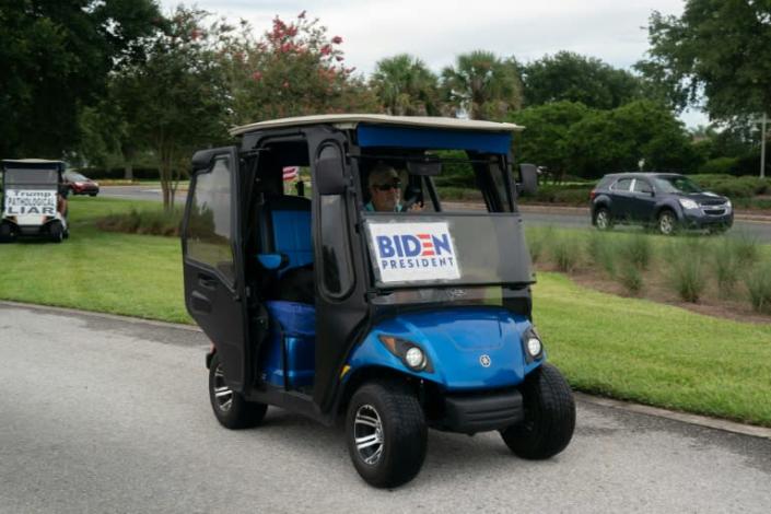 Casey Marr, a retiree from New Jersey drives his golf cart with a Biden for president sign after staging a daily protest against President Donald Trump in Orlando, Florida on July 23, 2020