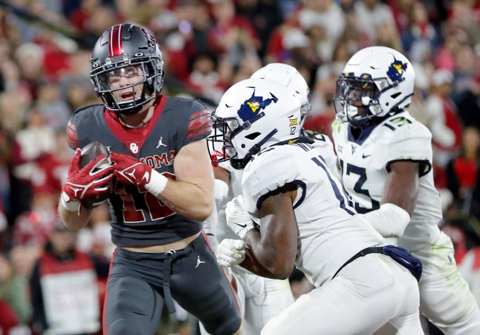 Oklahoma's Drake Stoops (12) scores a touchdown as West Virginia's Anthony Wilson (12) defends in the second half of a college football game between the University of Oklahoma Sooners and the West Virginia Mountaineers at Gaylord Family-Oklahoma Memorial Stadium in Norman, Okla., Saturday, Nov., 11, 2023.