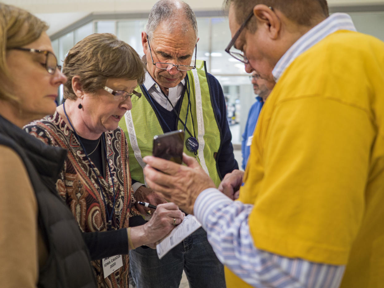 Carl Voss, the precinct chair for Precinct 55, verifies results at the caucus site for precinct 55