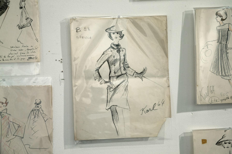 In this Monday, Dec. 30, 2013 photo, one of the few signed drawings that Karl Lagerfeld did, hang on the wall of the Modern Auction house in West Palm Beach, Fla. Most in-house designers are not allowed to sign their work. A 50-year-old archive of some of Karl Lagerfeld’s early fashion designs is going up for auction in Florida. In the 1960s, Lagerfeld was designing for Elizabeth Taylor and other celebrities while working for the House of Tiziani in Rome. (AP Photo/J Pat Carter)