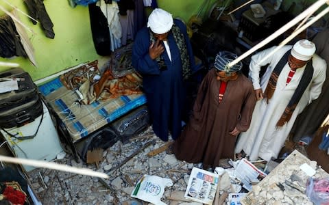 People check the damage created by debris, after ballistic missiles fired by Yemen's Houthi militia, fell at a house in Riyadh - Credit: Reuters