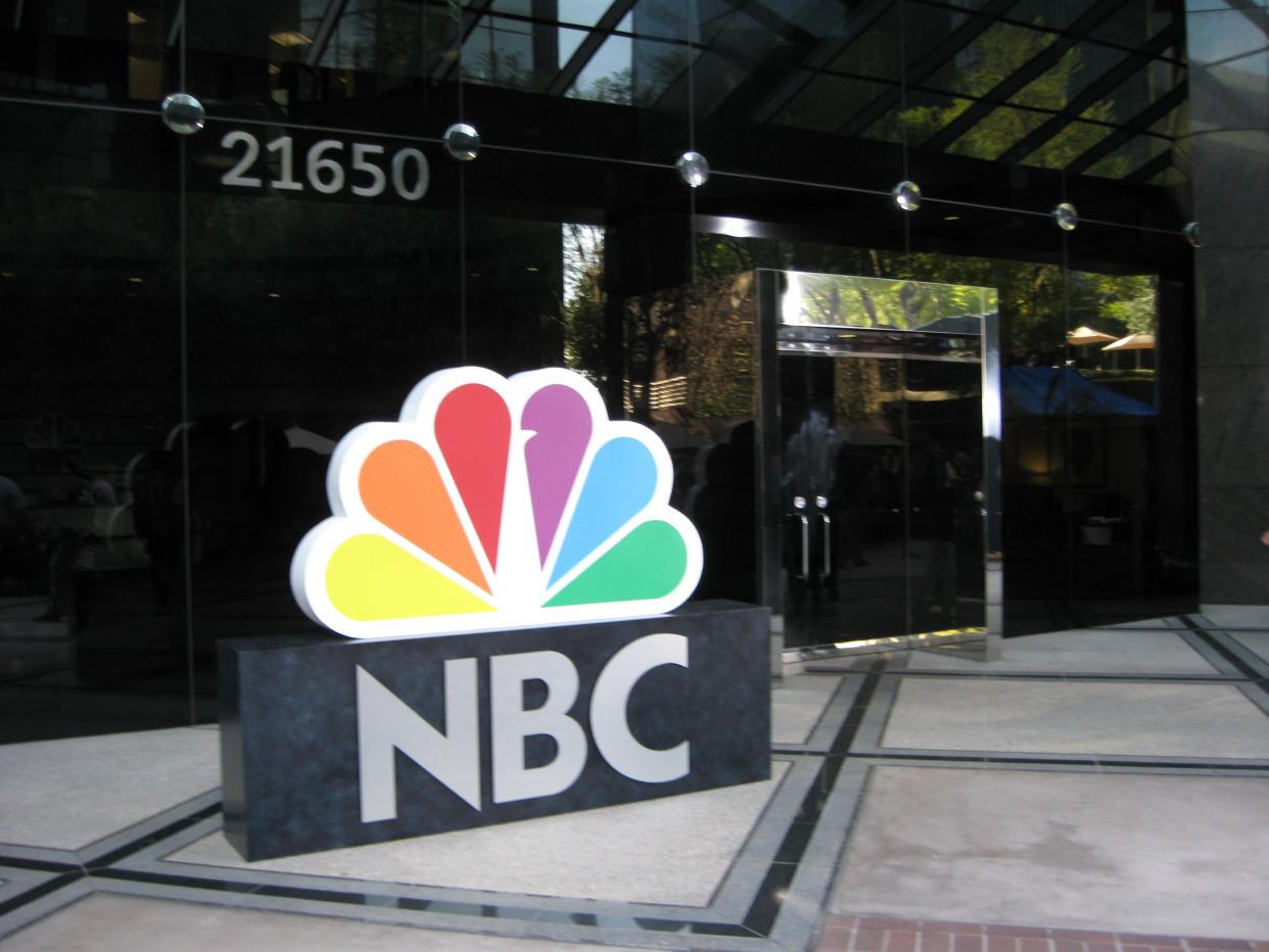 The NBC peacock logo in front of a building