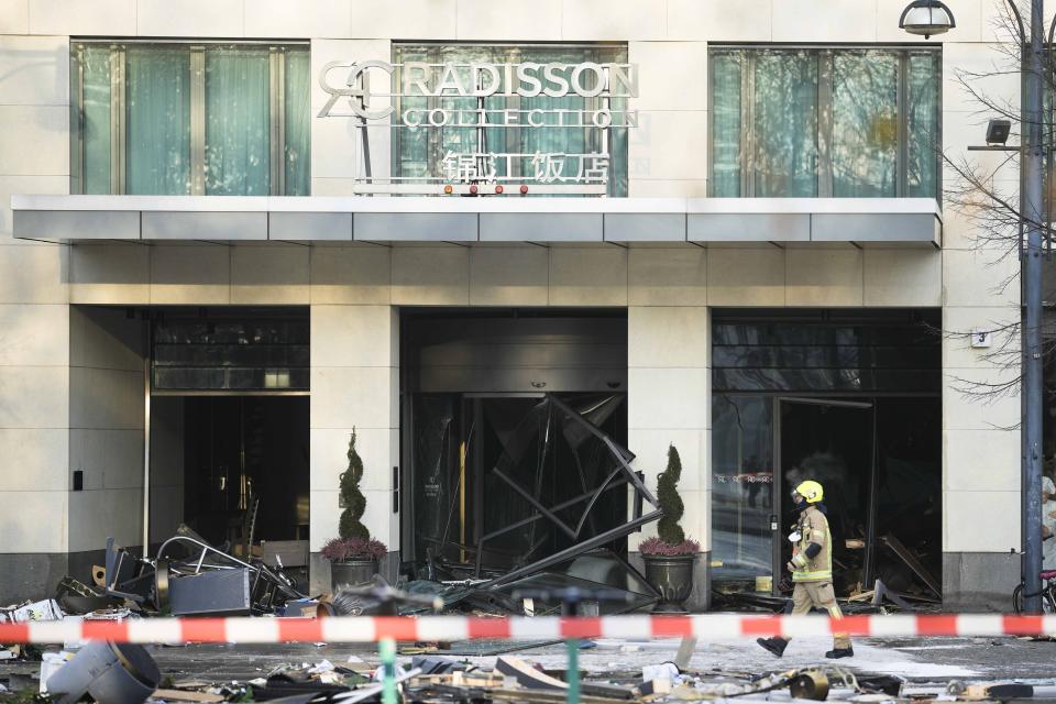 A firefighter inspects the scene with debris in front of a hotel where an huge aquarium has in Berlin, Germany, Friday, Dec. 16, 2022. German police say a huge fish tank in the center of Berlin has burst, causing a wave of devastation in and around the Sea Life tourist attraction. (AP Photo/Markus Schreiber)