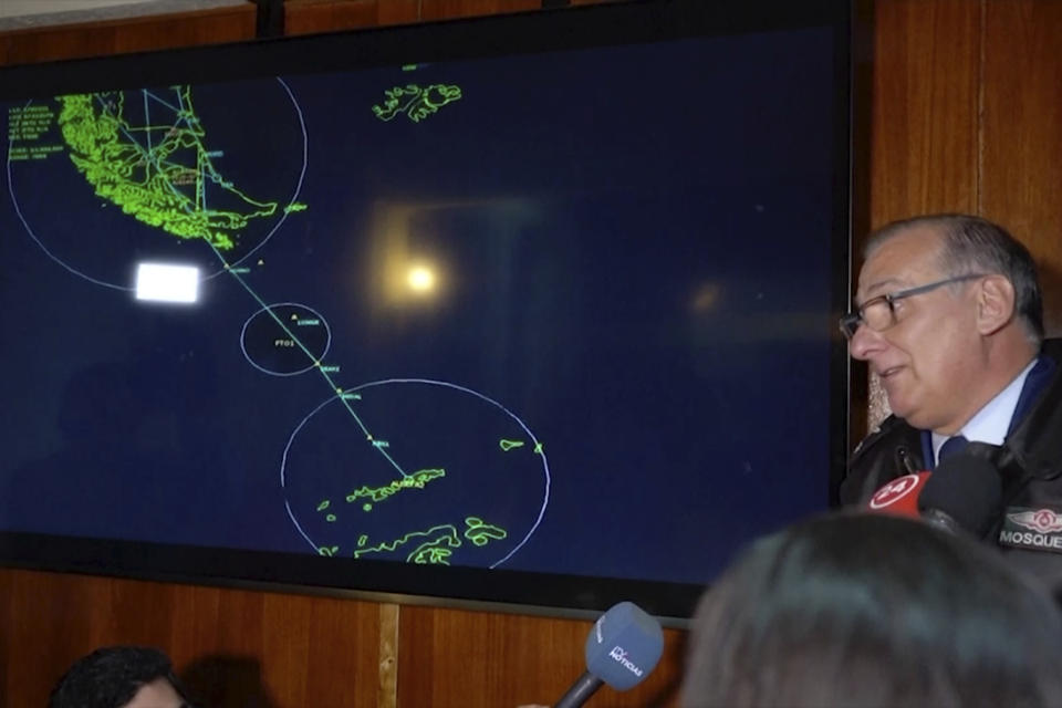 In this image made from video, Gen. Eduardo Mosqueira, right, of the Fourth Air Brigade speaks to the media next to a map of the area where the airplane is missing, in Punta Arenas, Chile, Monday, Dec. 9, 2019. Chile's air force lost radio contact with a transport plane carrying 38 people on a flight Monday evening to the country's base in Antarctica, and authorities indicated several hours later that they were not optimistic about the aircraft's fate. The military said earlier that it had declared an alert and activated search and rescue teams. (AP Photo)