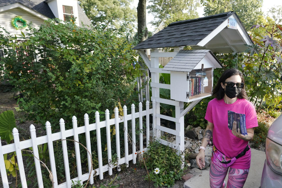 In this Saturday, Oct. 16, 2021, photo Lucy Hartman, of Planned Parenthood Advocates of Virginia leaves a home after leaving literature while canvassing the area to encourage voters to vote in Richmond, Va. (AP Photo/Steve Helber)