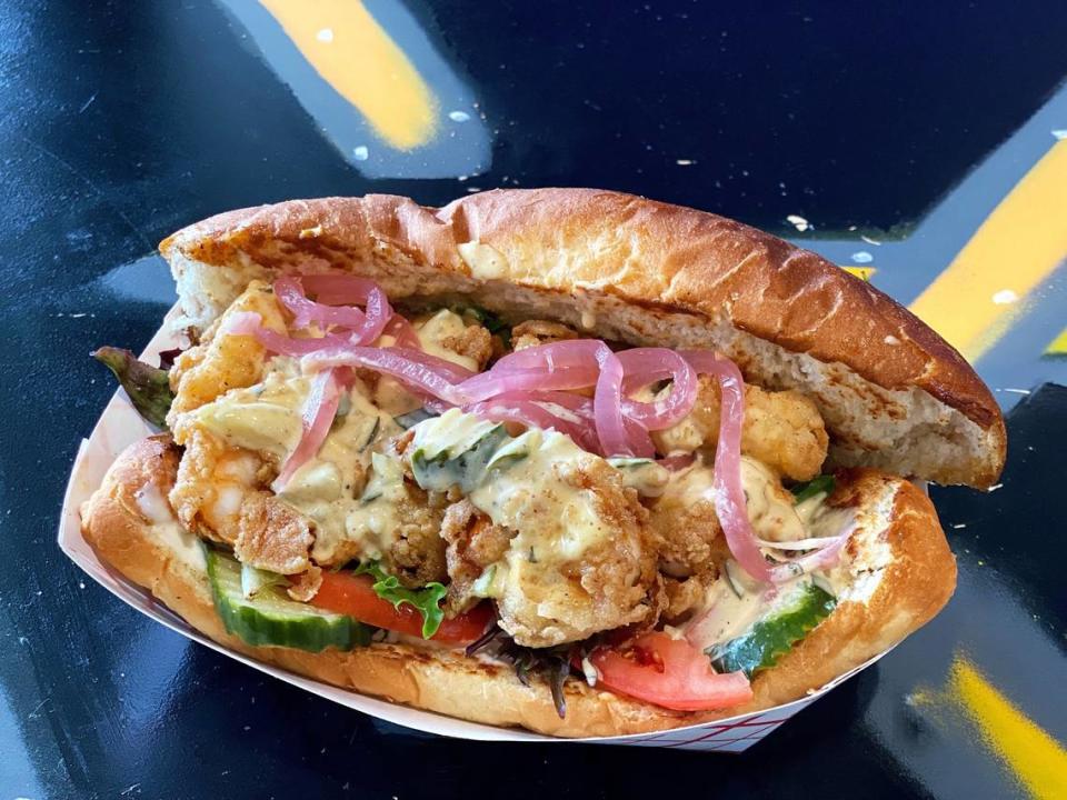 What The Fries' Shrimp Po Boy: Fried shrimp, lettuce, tomato, house-made pickles and Yum Yum remoulade on a toasted hoagie. 