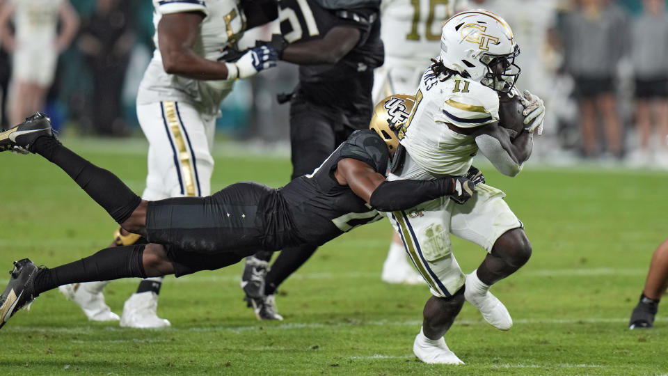 Georgia Tech running back Jamal Haynes (11) is stopped by Central Florida defensive back William Wells (29) during the first half of the Gasparilla Bowl NCAA college football game Friday, Dec. 22, 2023, in Tampa, Fla. (AP Photo/Chris O'Meara)