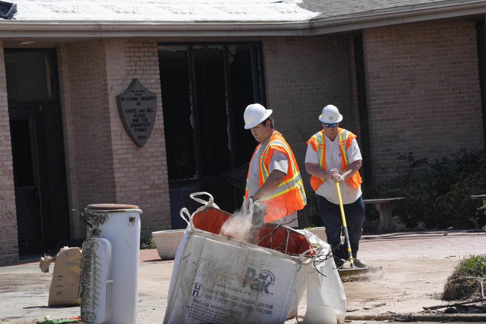 Workers sweep up the roofing and window debris outside the Rolling Fork, Miss., Unit of the Sharkey-Issaquena County Library, which was destroyed by the March 24 killer tornado, March 29, 2023. Many area residents are hopeful the county seat will be rebuilt with improvements to the city's infrastructure. (AP Photo/Rogelio V. Solis)