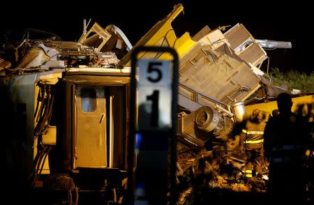 Rescuers work at the site where two passenger trains collided in the middle of an olive grove in the southern village of Corato, near Bari, Italy, July 12, 2016. REUTERS/Alessandro Garofalo