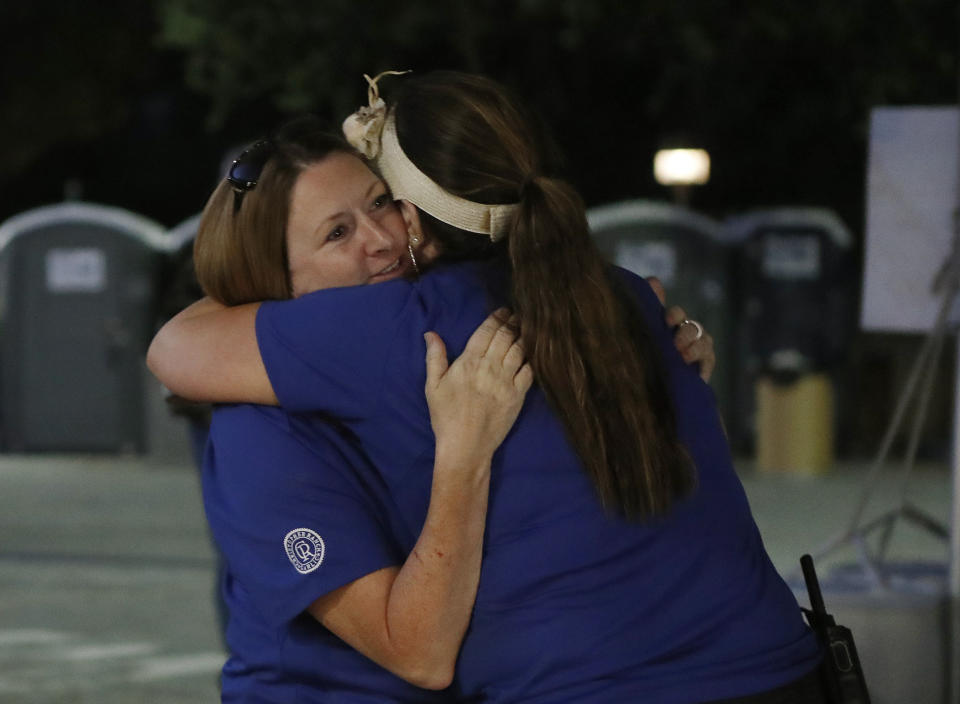 Gilroy Garlic festival volunteer Denise Buessing, left, embraces fellow volunteer Marsha Struzik at a reunification center in a parking lot at Gavilan College following a deadly shooting at the annual food festival (Picture: AP)