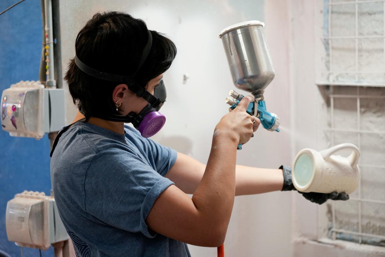 An employee sprays a commemorative stein for Oktoberfest Zinzinnati 2024.