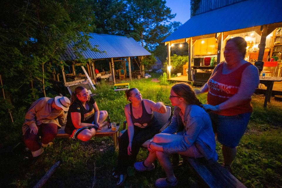 After sharing a meal on a warm Saturday in June 2022, Tessa Young, third from left, and Sherry Turner, at far right, discuss the changes their community faced after the massacre in Portapique that became Canada's deadliest mass shooting. The community is working to heal by building a new community center.