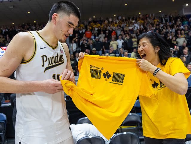 <p>Michael Hickey/Getty</p> Zach Edey is presented with a tee shirt from his mother following the game against the Alabama Crimson Tide on December 9, 2023 in Toronto, Canada.