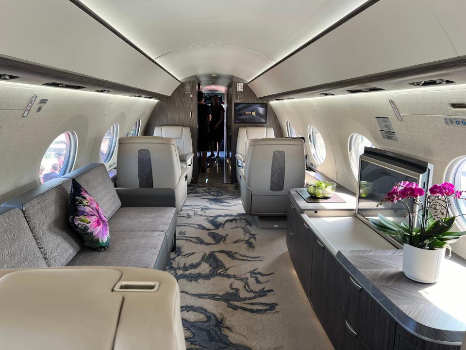 The living area of a Gulfstream G700 with a TV and a divan