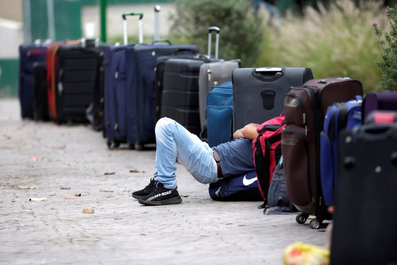 A migrant seeking for a U.S. work visa is seen resting in a park of downtown of Monterrey