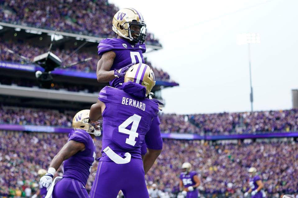 Washington wide receiver Giles Jackson, top, is lifted up by wide receiver Germie Bernard (4) after scoring a touchdown against Oregon during the first half of an NCAA college football game, Saturday, Oct. 14, 2023, in Seattle. (AP Photo/Lindsey Wasson)