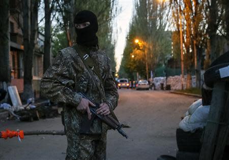 A pro-Russian armed man stands guard at a barricade near the state security service building in Slaviansk, April 25, 2014. REUTERS/Gleb Garanich