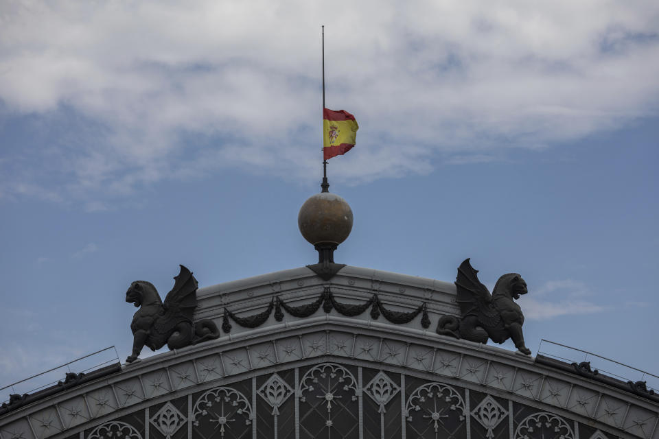 A Spanish flag hoisted to half-staff for the victims of COVID-19, flutters atop of the dome of the Atocha train station in Madrid, Spain, Tuesday, May 26, 2020. The Spanish government has declared 10 days of mourning starting Wednesday for the nearly 27,000 people who have died with the novel coronavirus in Spain, the longest official mourning period in the country's 4-decade-old democracy. (AP Photo/Bernat Armangue)