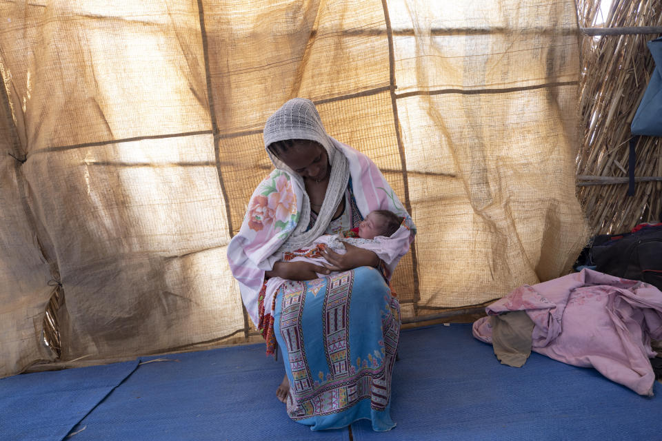 Lemlem Gebrehiwet, a 20-year-old Tigrayan refugee, holds her 3-day-old daughter, Semhal, in their shelter in Hamdayet, eastern Sudan, near the border with Ethiopia, on March 16, 2021. Other Tigrayans were turned away because of who they were. "They started distributing new ID cards in Bahkar but only for Amhara and Wolkait," said Gebrehiwet, who fled while heavily pregnant and gave birth three days after reaching Sudan. (AP Photo/Nariman El-Mofty)