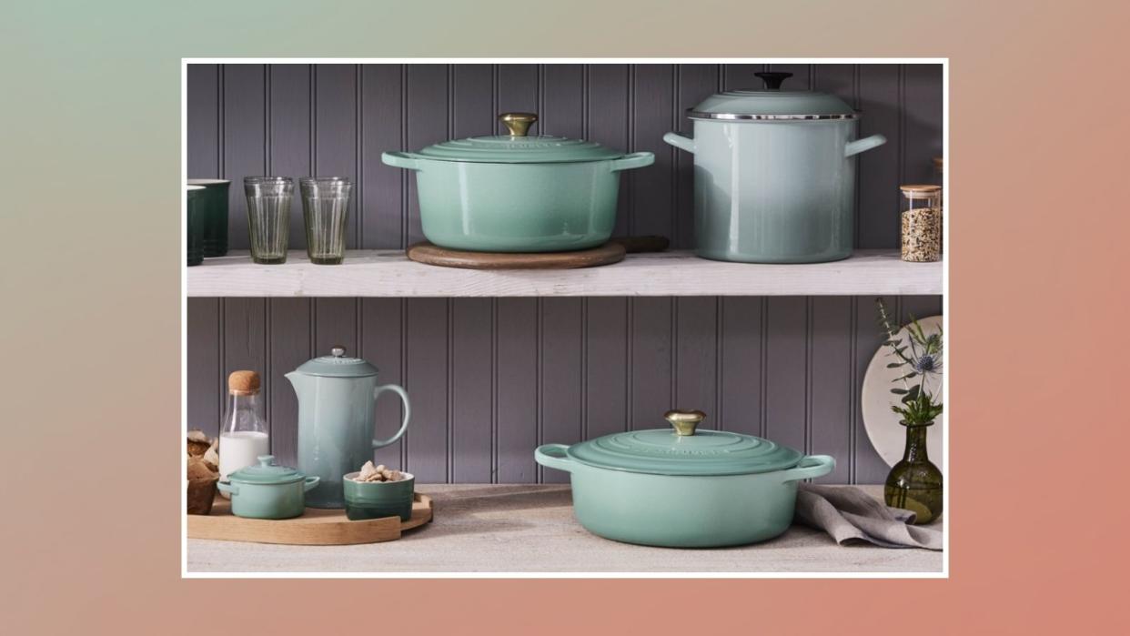  New Le Creuset color, sage, in two rows of cookware in the kitchen . 