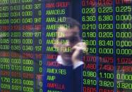 An office worker talks on his phone as he looks the stock board at the Australian Securities Exchange (ASX) building in central Sydney June 15, 2012. REUTERS/Daniel Munoz