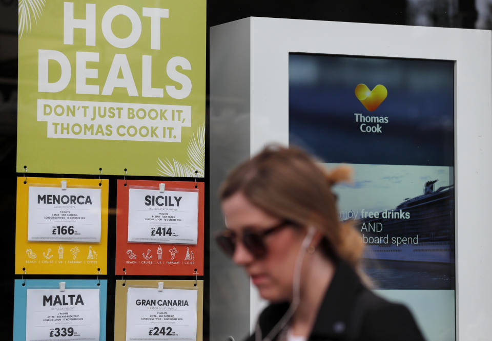 A woman walks past a closed Thomas Cook travel shop in London, Monday, Sept. 23, 2019. British tour company Thomas Cook collapsed early Monday after failing to secure emergency funding, leaving tens of thousands of vacationers stranded abroad. (AP Photo/Frank Augstein)