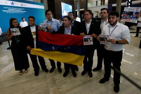 A group of Venezuelan opposition lawmakers and members of the Venezuela diaspora protest inside the venue where the Organization of American States (OAS) 47th General Assembly is taking place in Cancun, Mexico June 21, 2017. REUTERS/Carlos Jasso