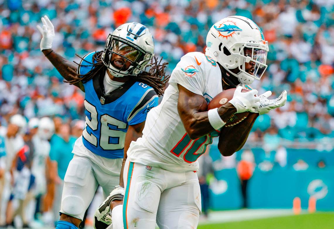 Miami Dolphins wide receiver Tyreek Hill (10) catches a touchdown pass by quarterback Tua Tagovailoa (1) in the second quarter as Carolina Panthers cornerback Donte Jackson (26) defends at Hard Rock Stadium in Miami Gardens on Sunday, October 15, 2023. Al Diaz/adiaz@miamiherald.com