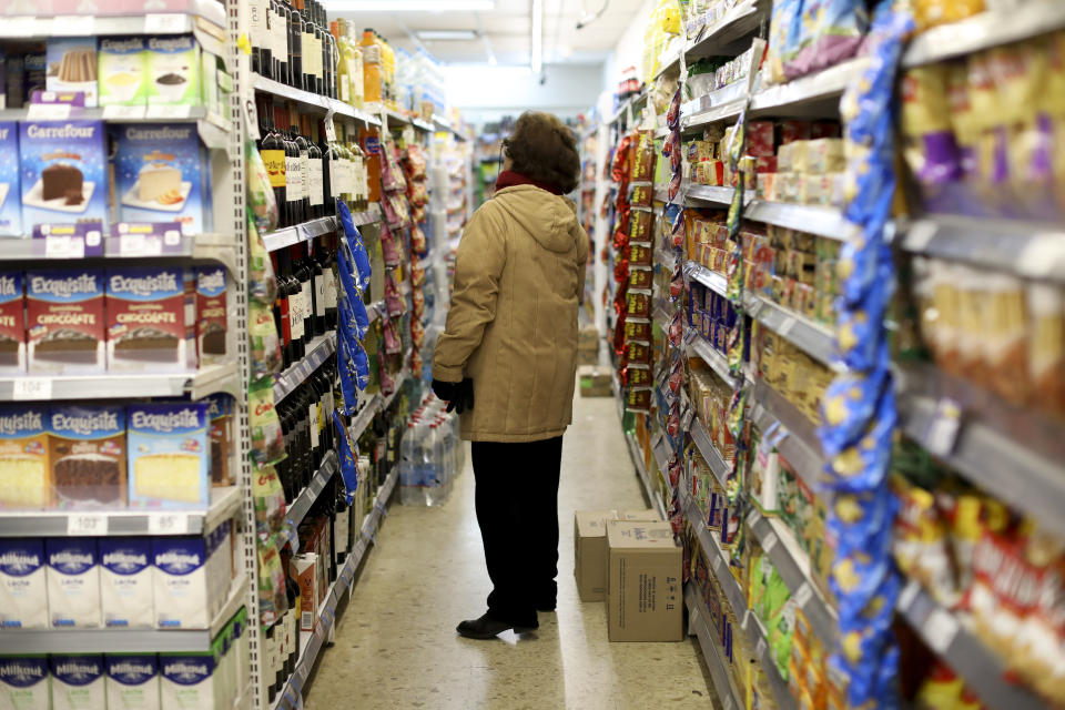 A woman checks prices at a supermarket in Buenos Aires, Argentina, Wednesday, Aug. 14, 2019. President Mauricio Macri announced economic relief for poor and working-class Argentines that include an increased minimum wage, reduced payroll taxes, a bonus for informal workers and a freeze in gasoline prices. The conservative leader said Wednesday he's acting in recognition of the "anger" Argentines expressed in Sunday's primary election, when Macri trailed his populist rival by 15 percentage points. (AP Photo/Natacha Pisarenko)