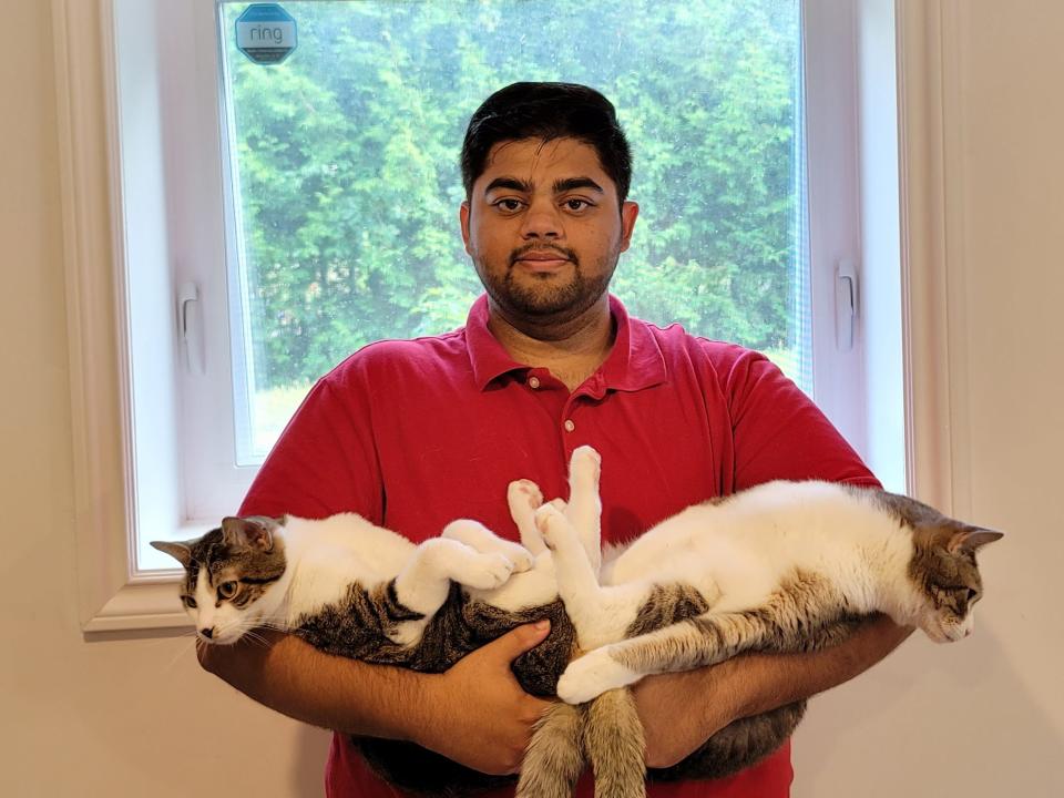 Abbas Zoeb holding his two cats.