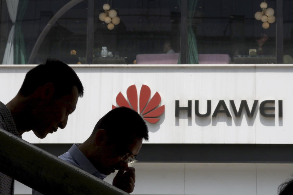 In this May 16, 2019, photo, Chinese men pass by a Huawei retail shop in Beijing. Stepping up the pressure on Beijing, the U.S. Commerce Department has effectively barred U.S. companies from selling or transferring technology to Huawei Technologies, the world's biggest maker of network gear, No. 2 smartphone manufacturer and a champion of Chinese industry. (AP Photo/Ng Han Guan)