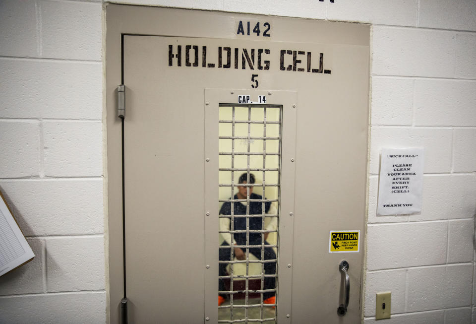 A detainee sits in a holding cell at the Stewart Detention Center, Friday, Nov. 15, 2019, in Lumpkin, Ga. The city's 1,172 residents are outnumbered by the roughly 1,650 male detainees that ICE said were being held in the detention center in late November. (AP Photo/David Goldman)