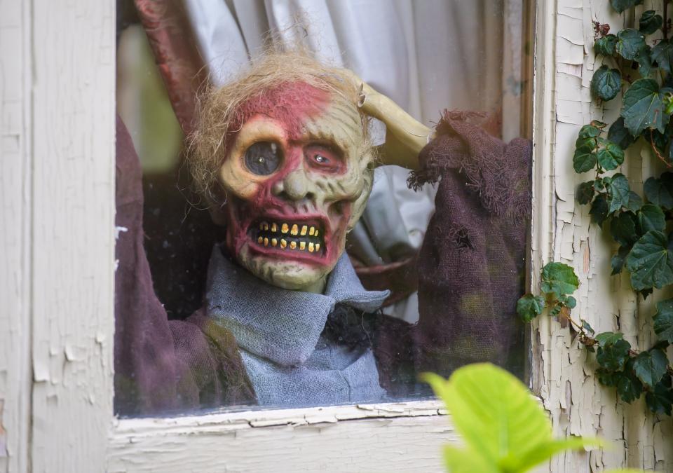 A zombie peeks through a window Thursday, Oct. 27, 2022 in the castle on Grandview Drive in Peoria Heights.