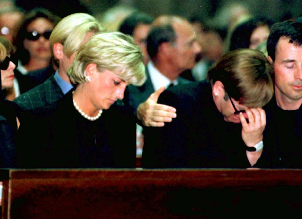 Princess Diana and pop star Elton John grieve for slain fashion designer Gianni Versace as Elton John weeps openly comforted by a friend at a memorial mass in Milan.  Versace was shot dead in front of his Miami Beach mansion early last week. (Photo: Reuters)