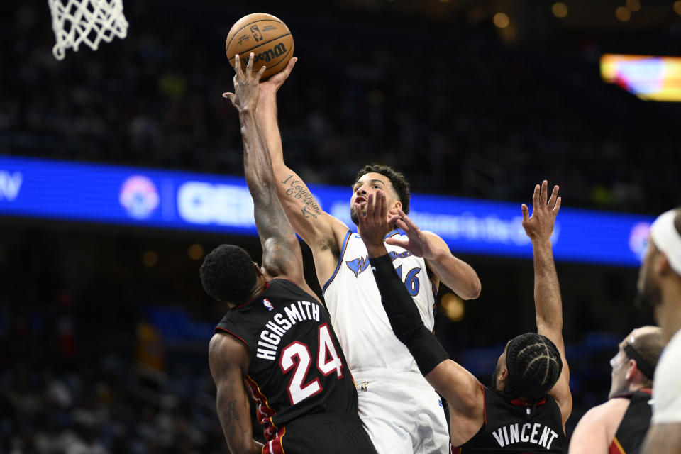 Washington Wizards forward Anthony Gill (16) goes to the basket against Miami Heat forward Haywood Highsmith (24) and guard Gabe Vincent during the first half of an NBA basketball game Friday, April 7, 2023, in Washington. (AP Photo/Nick Wass)