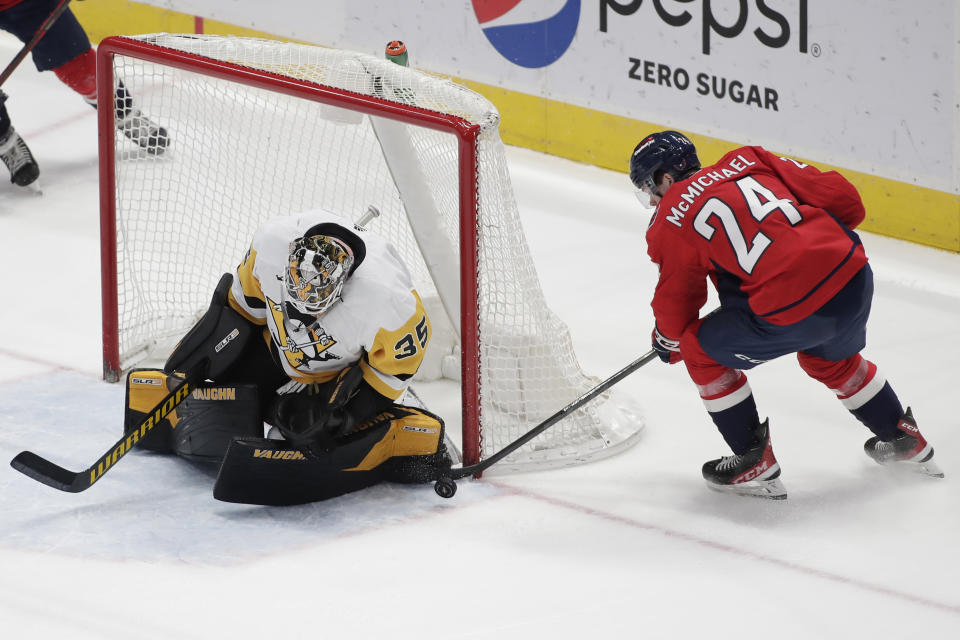 Washington Capitals' Connor McMichael (24) attempts a shot on Pittsburgh Penguins goalie Tristan Jarry (35) during the second period of an NHL hockey game Friday, Dec. 10, 2021, in Washington. (AP Photo/Luis M. Alvarez)