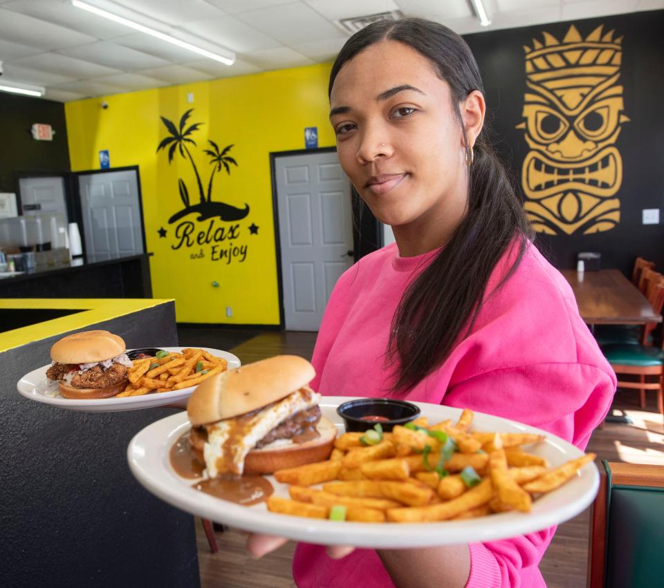 Pineapple Express employee Kendra Wasley shows off some Hawaiian-inspired burgers on the menu at the Barrancas Avenue eatery on Wednesday, Feb. 14, 2024.