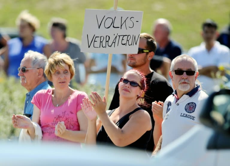 A woman holds a placard reading "traitor of the people" at a protest during Merkel's visit to Heidenau on August 26, 2015