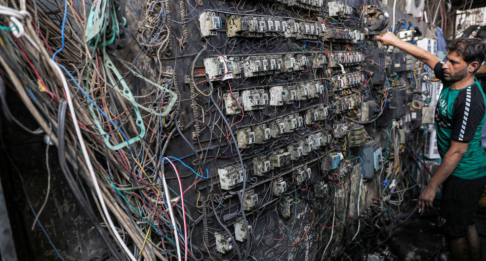 A technician controls an electric switch board connecting homes to privately-owned electricity generators in a suburb of Iraq's capital Baghdad on June 30, 2021 as the national electric grid is experiencing outages amidst a severe heat wave. (Photo by AHMAD AL-RUBAYE / AFP) (Photo by AHMAD AL-RUBAYE/AFP via Getty Images)