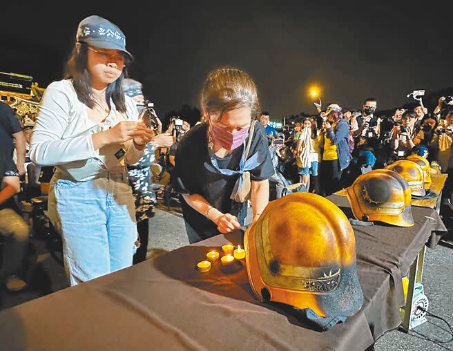 屏東明揚大火造成4名消防員因公殉職，消防員工作權益促進會9日在凱道前舉行國殤日晚會，參與群眾點蠟燭悼念。（陳怡誠攝）