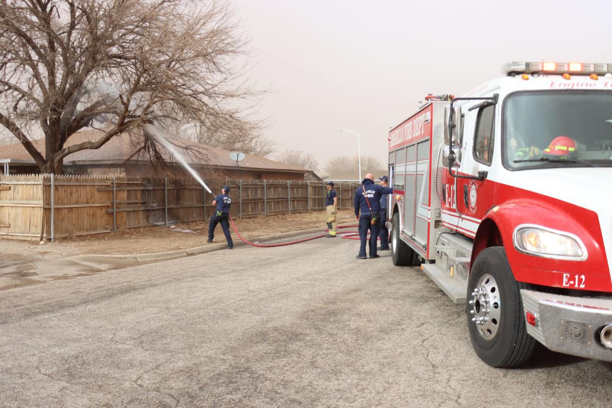 Amarillo Fire Department crews worked to extinguish a fire that spread to a tree due to a downed power line Sunday afternoon during a potent wind storm.