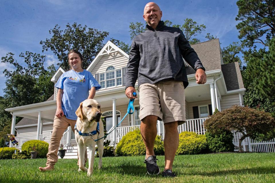 The Tinsley's, Jazmin and dad Kevin, along Jazmin's new service dog, Bonus, stand in front of the Tinsley family home in Rehoboth Beach, Wednesday, Sept. 27, 2023. Jazmin dreams of being a teacher and living independently one day.