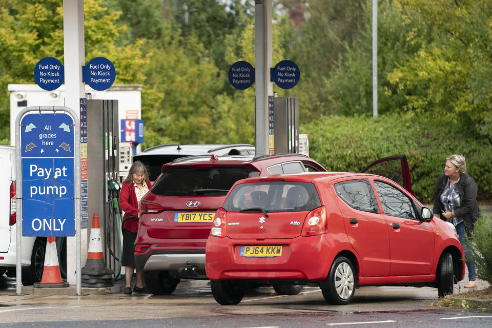 Members of the public are seen at a petrol station in Manchester, England, Monday, Sept. 27, 2021. British Prime Minister Boris Johnson is said to be considering whether to call in the army to deliver fuel to petrol stations as pumps ran dry after days of panic buying. ( AP Photo/Jon Super)