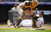 Colorado Rockies' Yonathan Daza, right, scores on a double hit by Trevor Story as San Diego Padres catcher Webster Rivas, left, fields the throw in the fourth inning of a baseball game Wednesday, June 16, 2021, in Denver. (AP Photo/David Zalubowski)