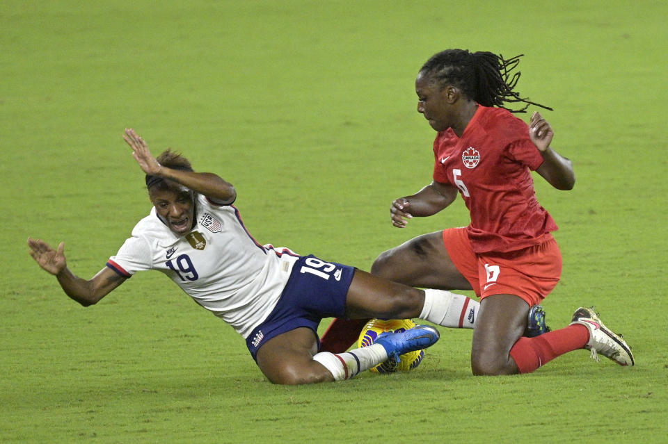 Canada forward Deanne Rose (6) separates the ball from United States defender Crystal Dunn (19) during the first half of a SheBelieves Cup women's soccer match, Thursday, Feb. 18, 2021, in Orlando, Fla. (AP Photo/Phelan M. Ebenhack)