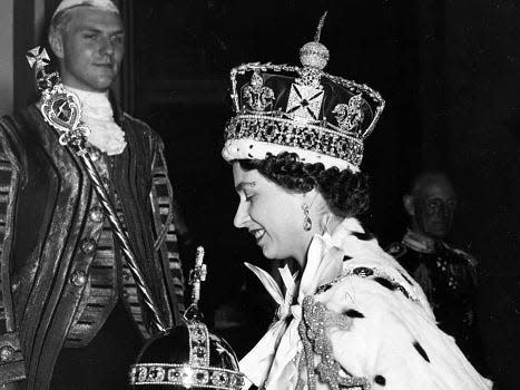 The queen wearing the St Edward's Crown, holding the orb and sceptres.